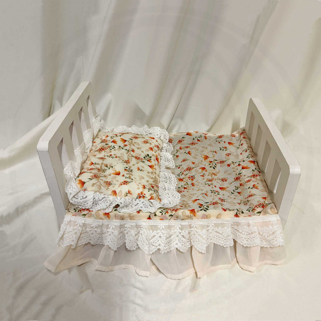 A 2-piece set featuring a newborn blanket and pillow with orange floral print and lace trim for newborn photography.