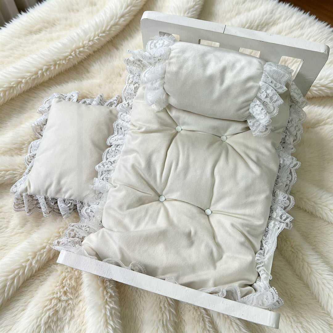 A 3-piece set featuring a tufted pearl white posing cushion and pillows with lace trim  for newborn photography.