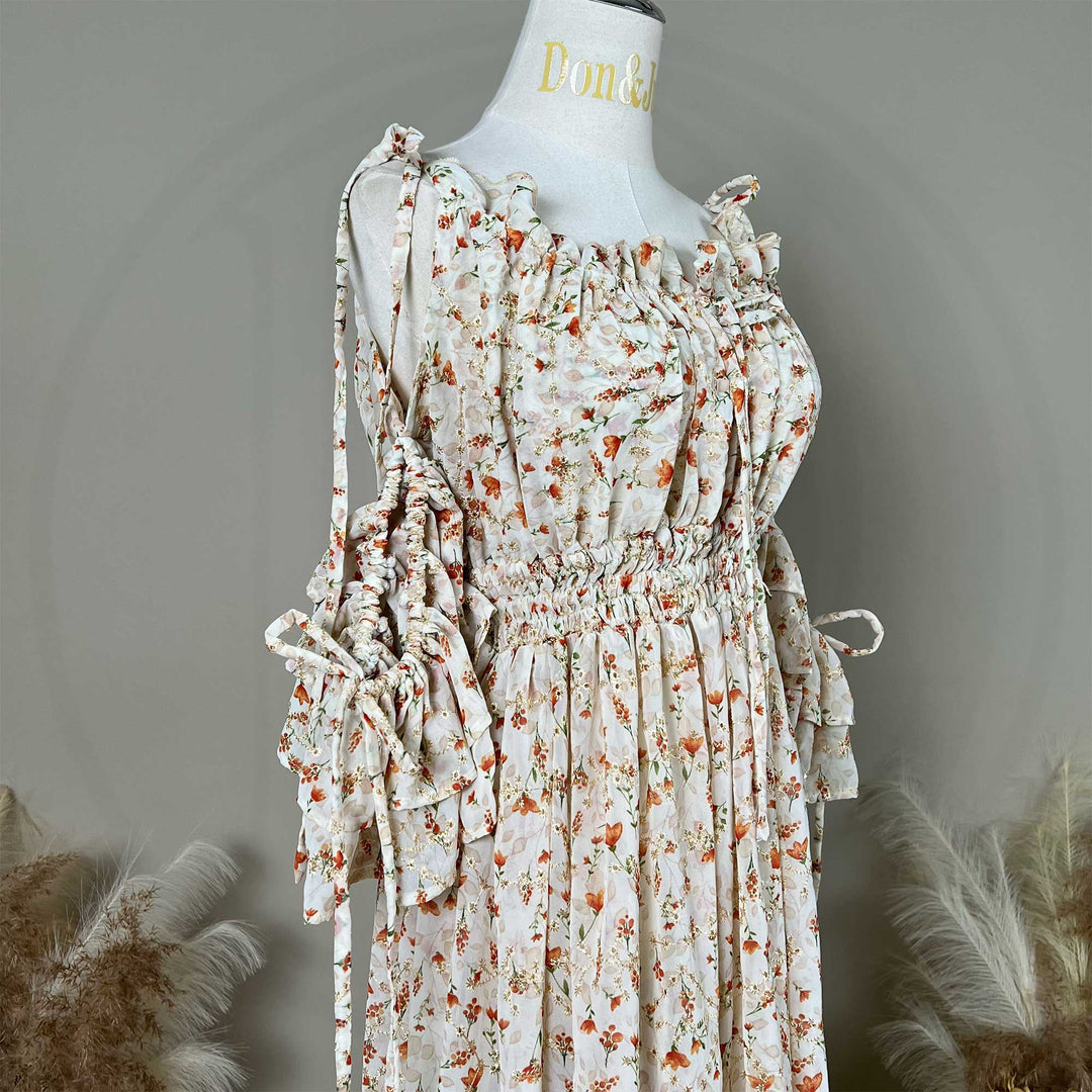 Close up of a mannequin displays an Alke floral off-shoulder gown with a train.
