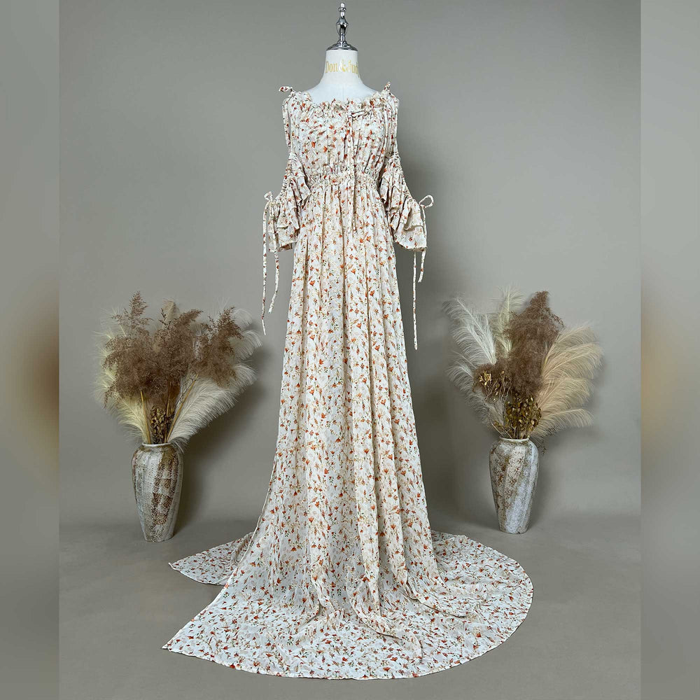 A mannequin displays an Alke floral off-shoulder gown with a train.