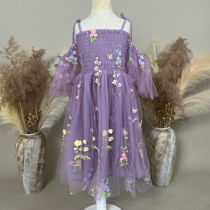 A mannequin displays an Ananke purple floral embroidered dress.