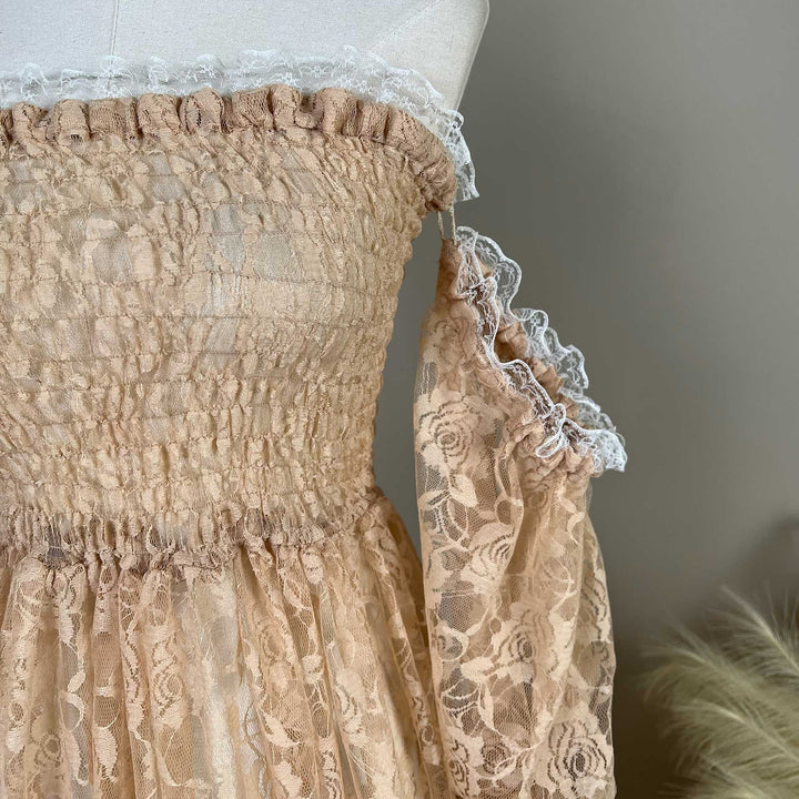 A close-up shows a khaki Selene lace strapless dress on a mannequin, featuring white lace trim on the smocked bodice and lantern sleeves.