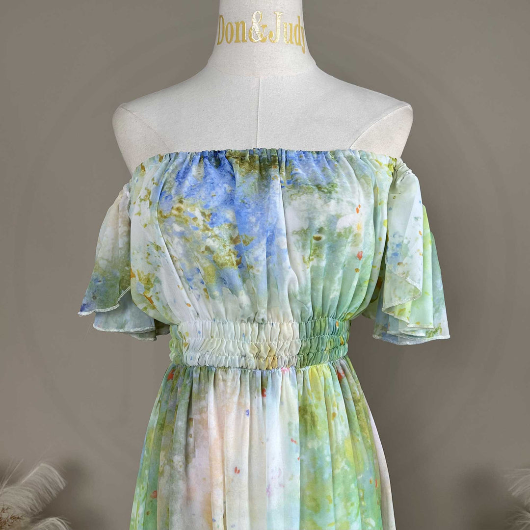 A close up of a mannequin displays a Achlys watercolor floral print maternity photography dress.