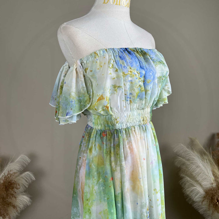 A close up of a mannequin displays a Achlys watercolor floral print maternity photography dress.