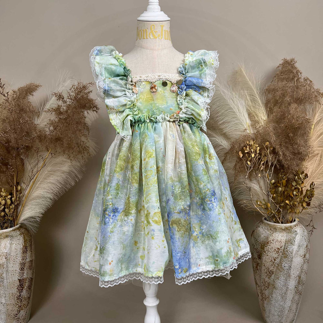 A mannequin displays a tie dye chiffon dress with ruffles. 