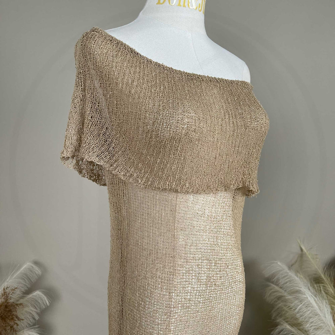 A Close up of a mannequin displays an Aletheia  camel off-shoulder neckline of a knitted fabric.