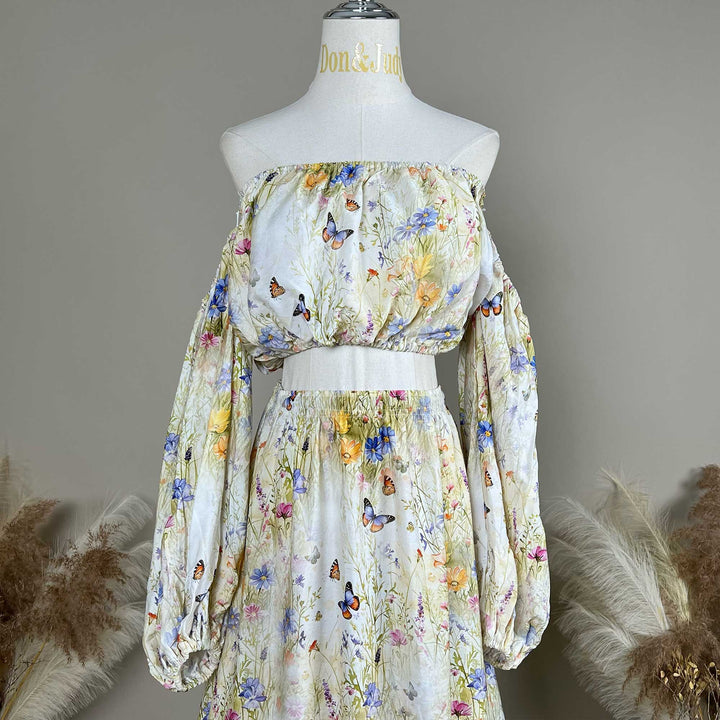 Close up of an Aphaea floral and butterfly print off-shoulder two-piece is displayed on a mannequin.