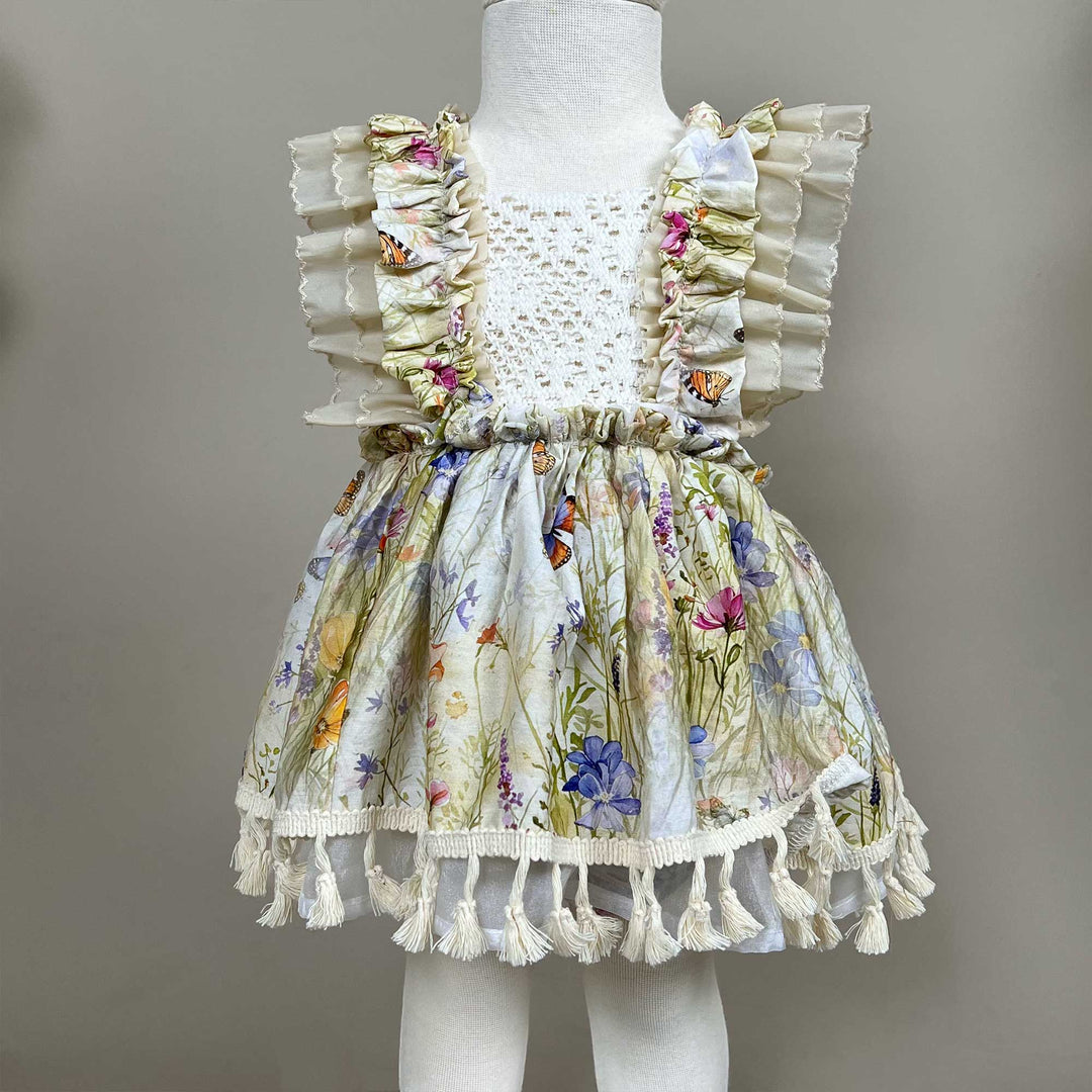 An Arachne floral tassel dress hangs on a mannequin.