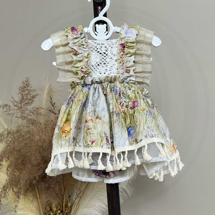An Arachne floral tassel dress hangs on a hanger.