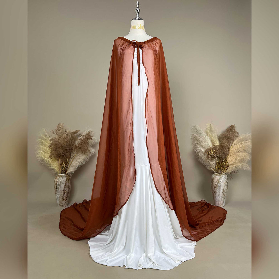 An Astraea satin maxi cape maternity dress with a terracotta chiffon cape is displayed on a mannequin.