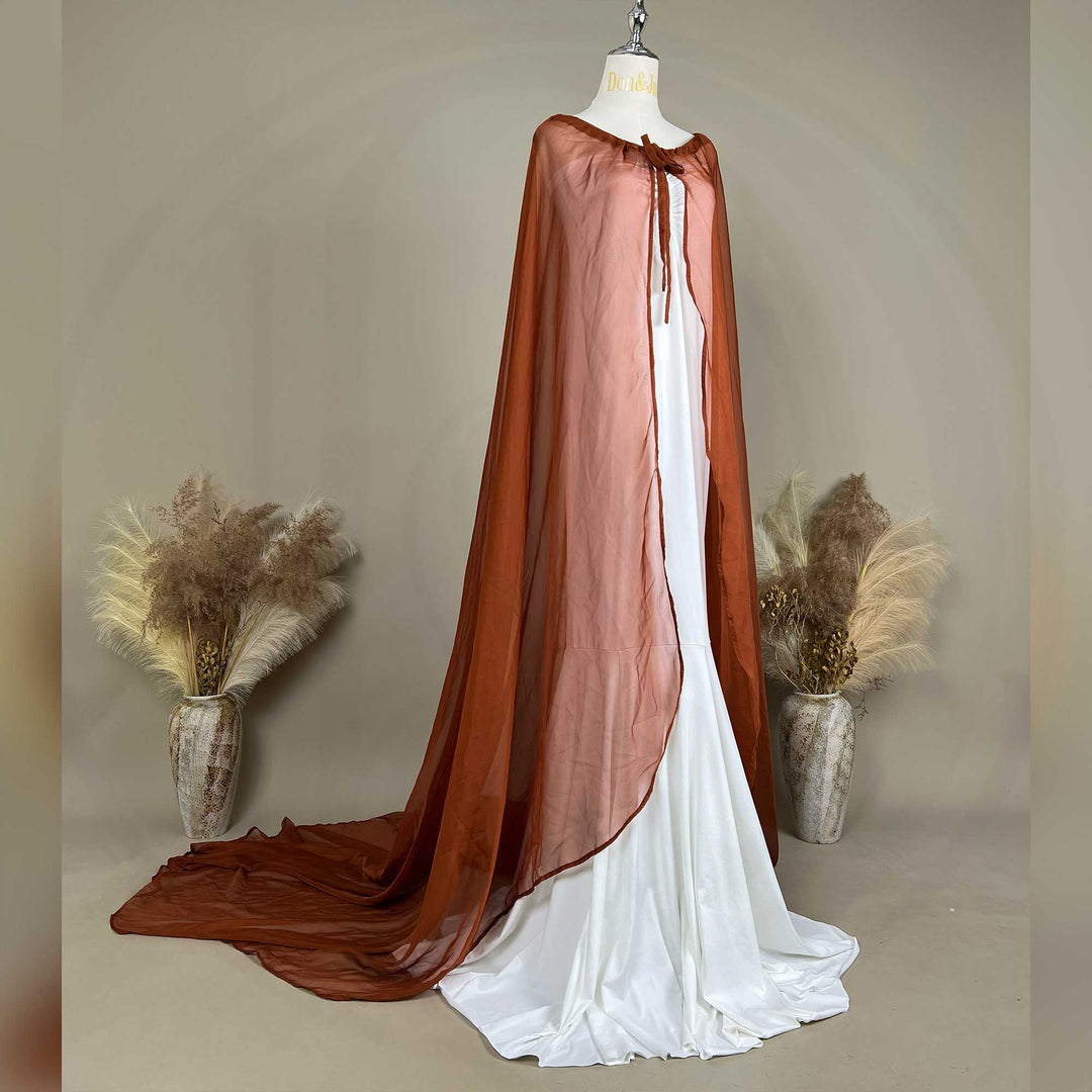 A side view of an Astraea satin maxi cape maternity dress with a terracotta chiffon cape is displayed on a mannequin.
