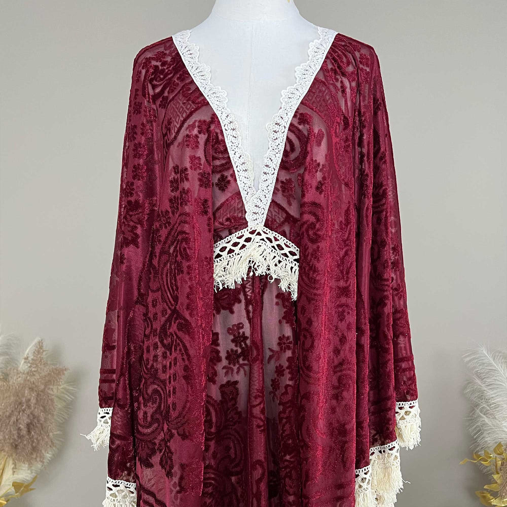A Red wine,A bacche dress with a velvet cape and a white lace inner layer is displayed on a mannequin.
