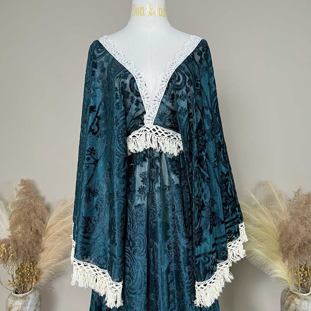 A Green,Bacche dress with a velvet cape and a white lace inner layer is displayed on a mannequin.