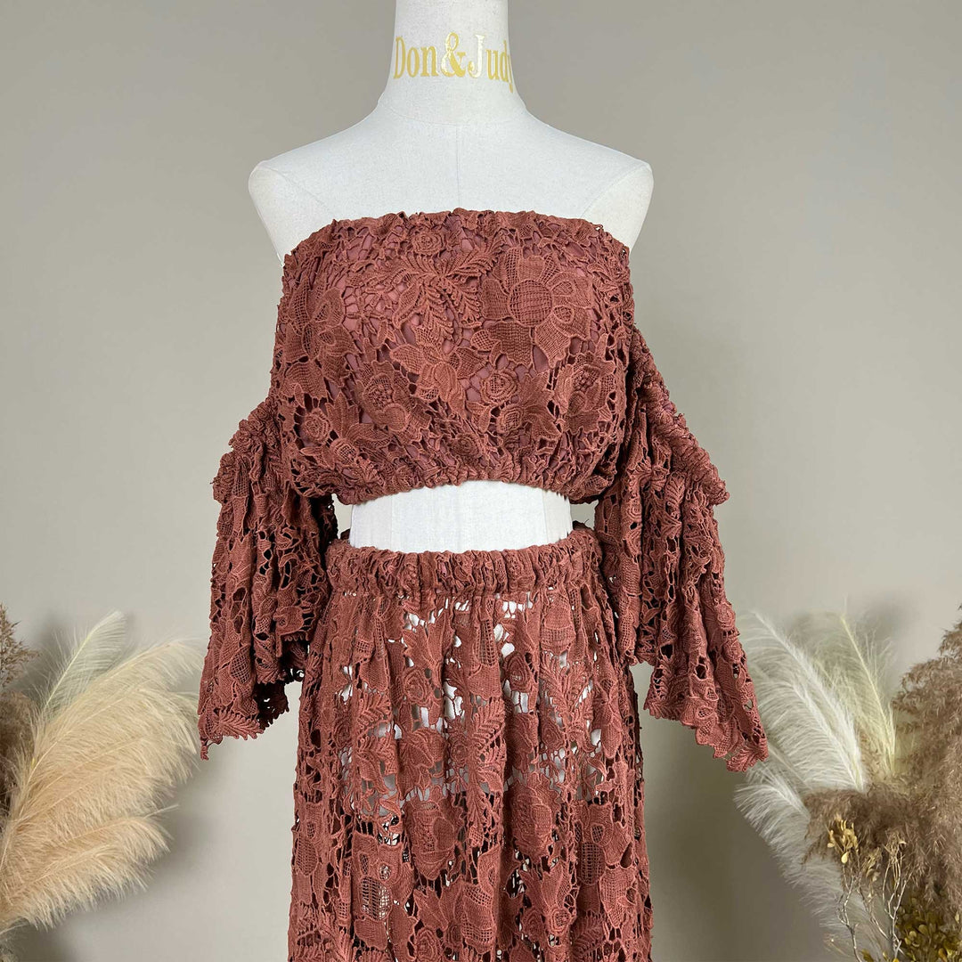 A terracotta two-piece lace maternity photography set displayed on a mannequin, featuring an off the shoulder ruffled crop top details.