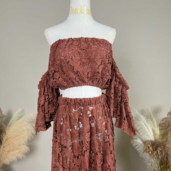 A terracotta two-piece lace maternity photography set displayed on a mannequin, featuring an off the shoulder ruffled crop top details.