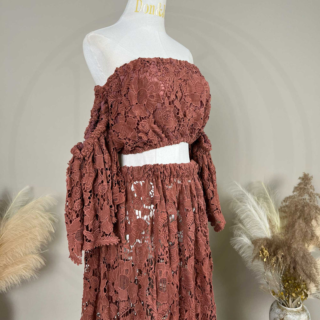 A terracotta two-piece lace maternity set displayed on a mannequin, featuring an off the shoulder ruffled crop top details.
