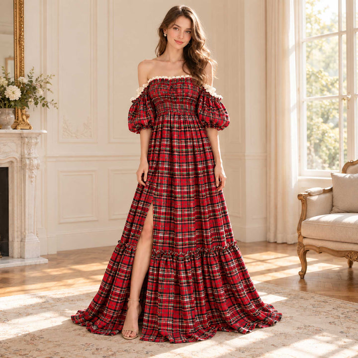 A woman in a Catubri red-green plaid off-shoulder maxi dress with puff sleeves, a side slit and a ruffled hem.
