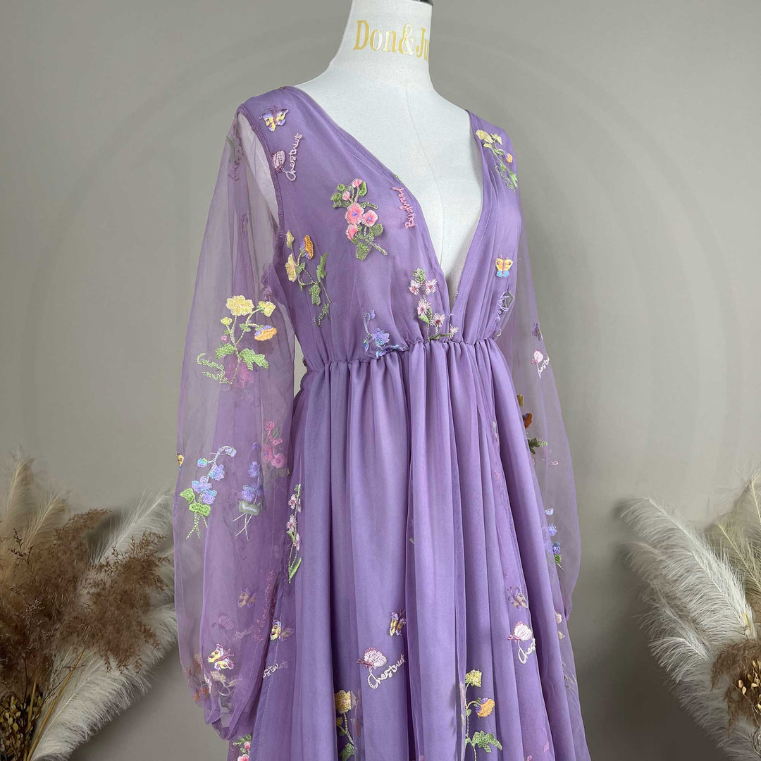 A Dike purple tulle long sleeve floral embroidered gown with a train is displayed on a mannequin.