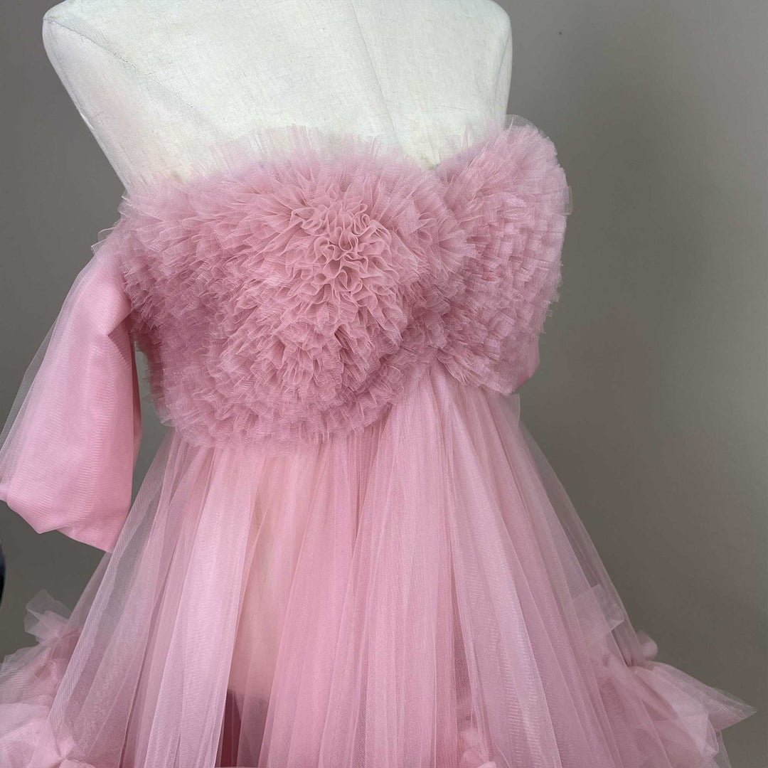 A close up of  mannequin displays a Electra pink strapless ruffled tulle gown.