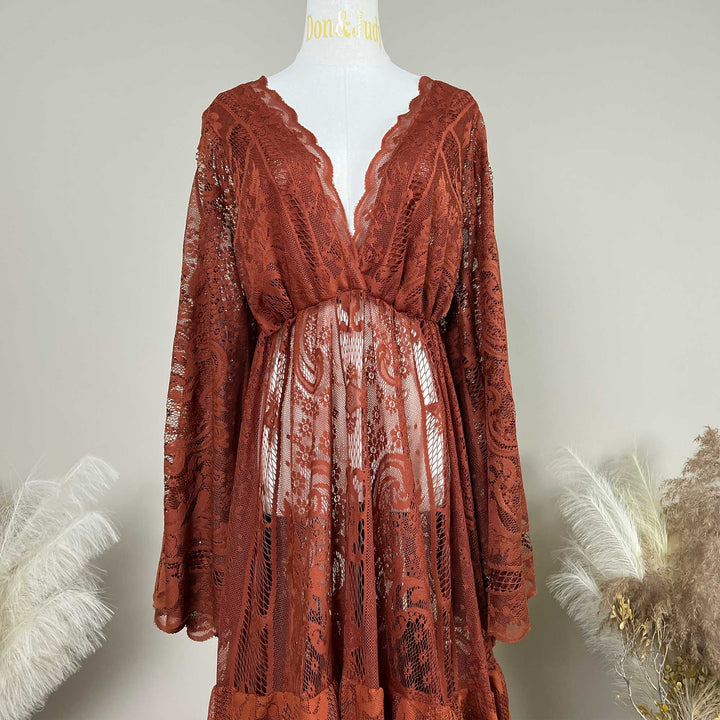 A terracotta lace robe displayed on a mannequin. The garment features a deep V-neckline with scalloped edges, long sleeves, and an open front design that reveals the midsection area.