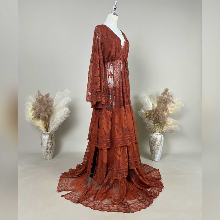 A Terracotta, harpocrates dress with tiered ruffle lace details is displayed on a mannequin against a neutral gray background.