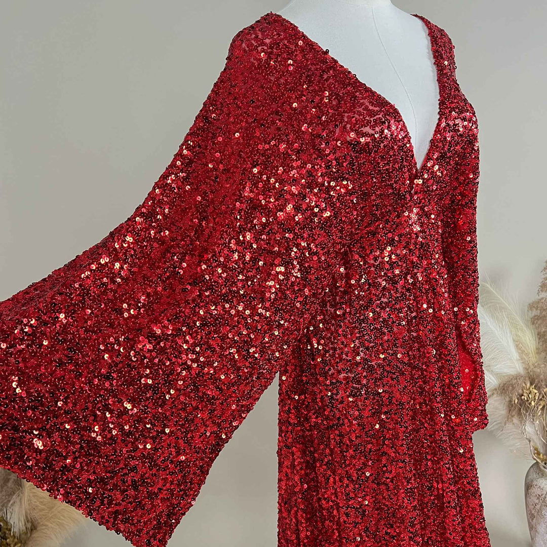 A red Mara dress sequined gown, featuring a V-neck and flared sleeves displayed on a mannequin.