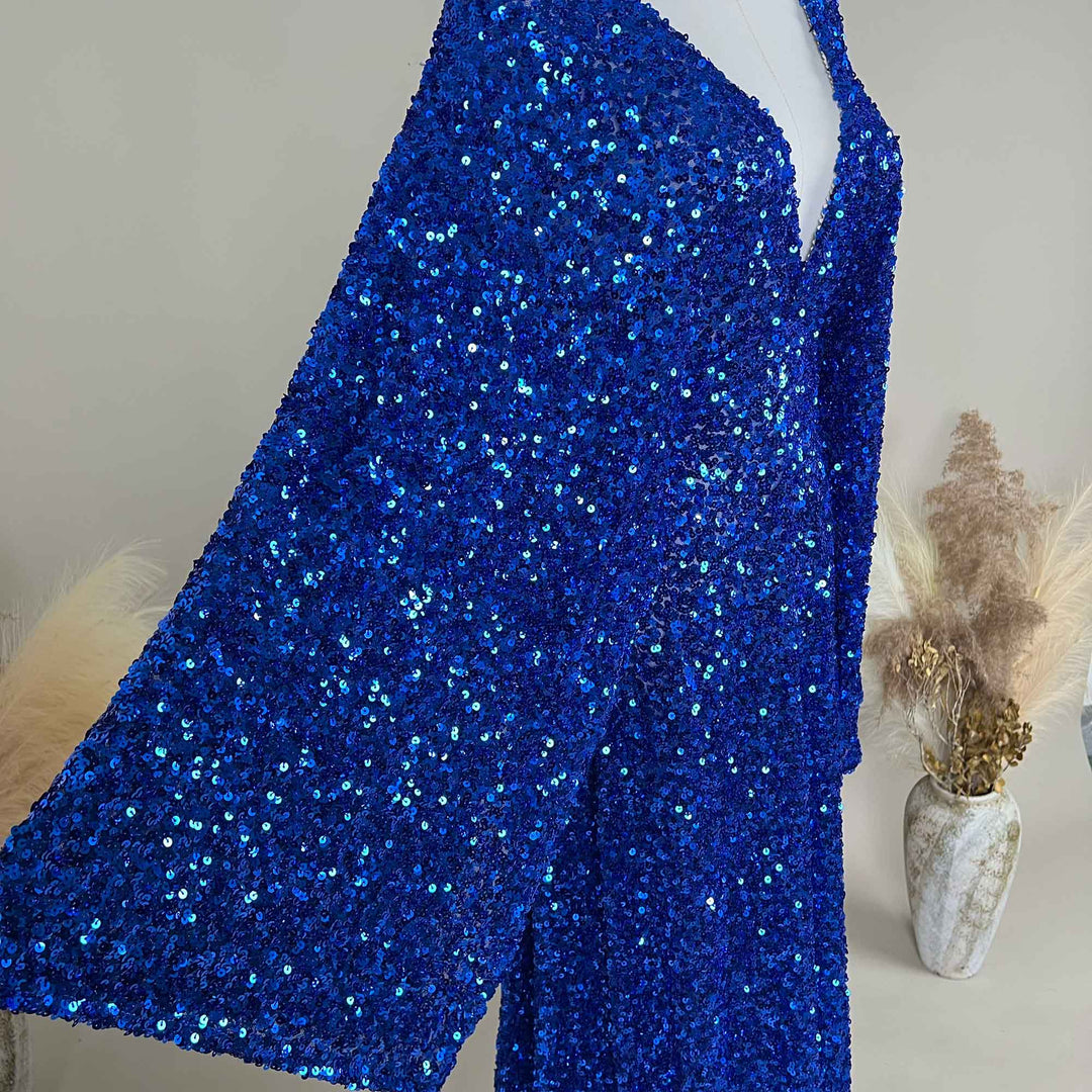 A sapphire blue Mara sequined gown is displayed on a mannequin, featuring a V-neck and flared sleeves. 