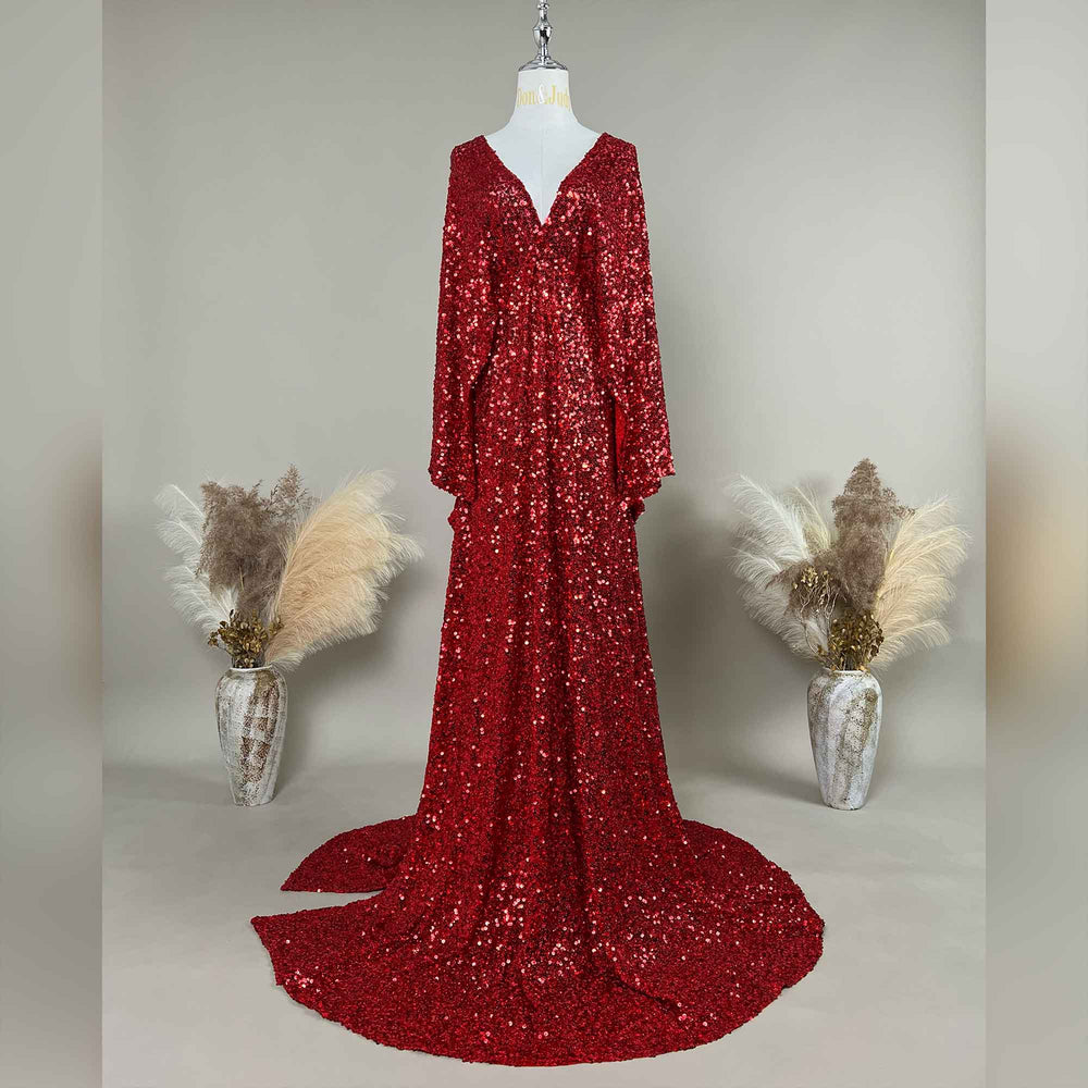 A Mara red sequined gown is displayed on a mannequin, featuring a V-neck and flared sleeves. The hem trails on the floor.