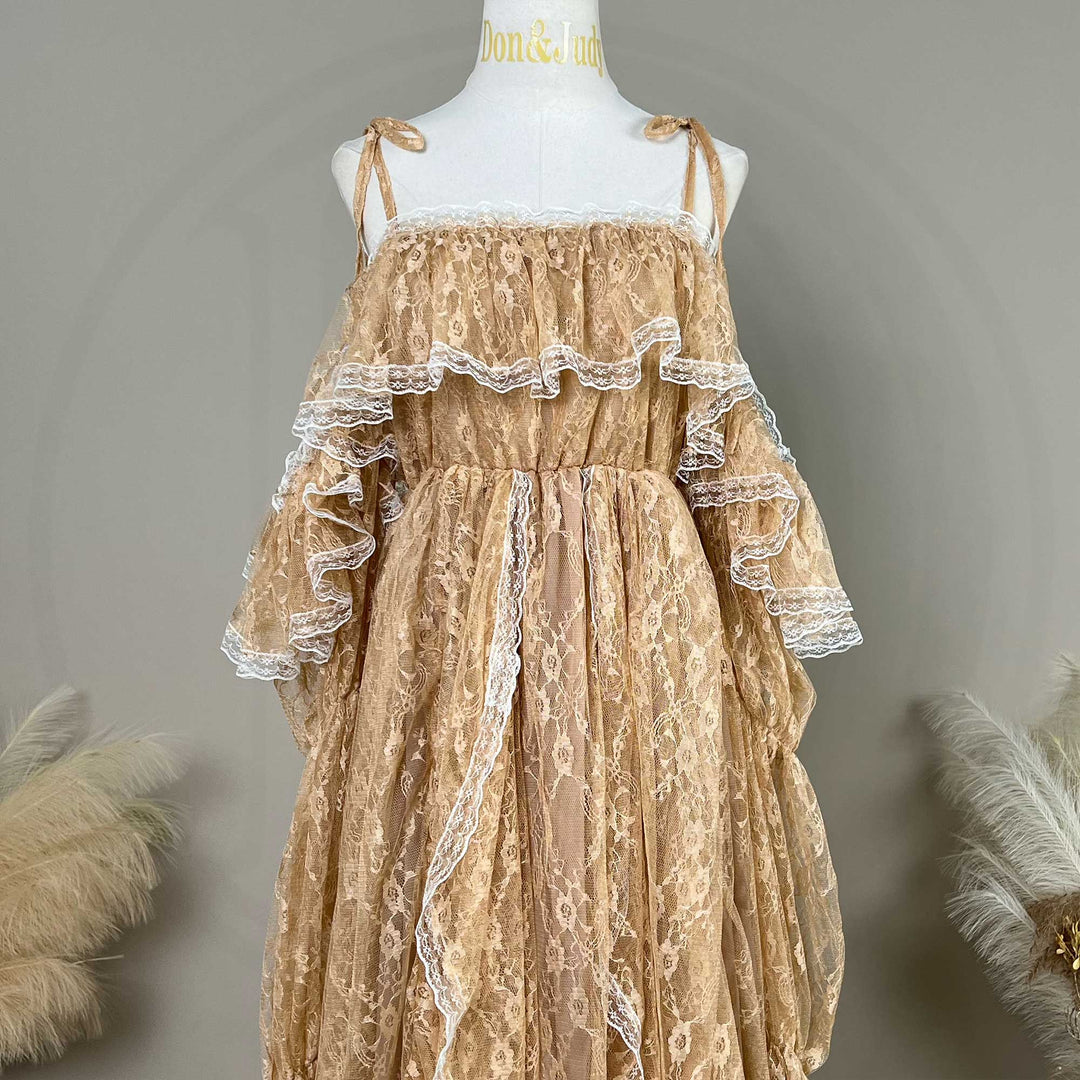 A Melinoe khaki lace maternity gown with cascading ruffles and a sweeping train is displayed on a mannequin.