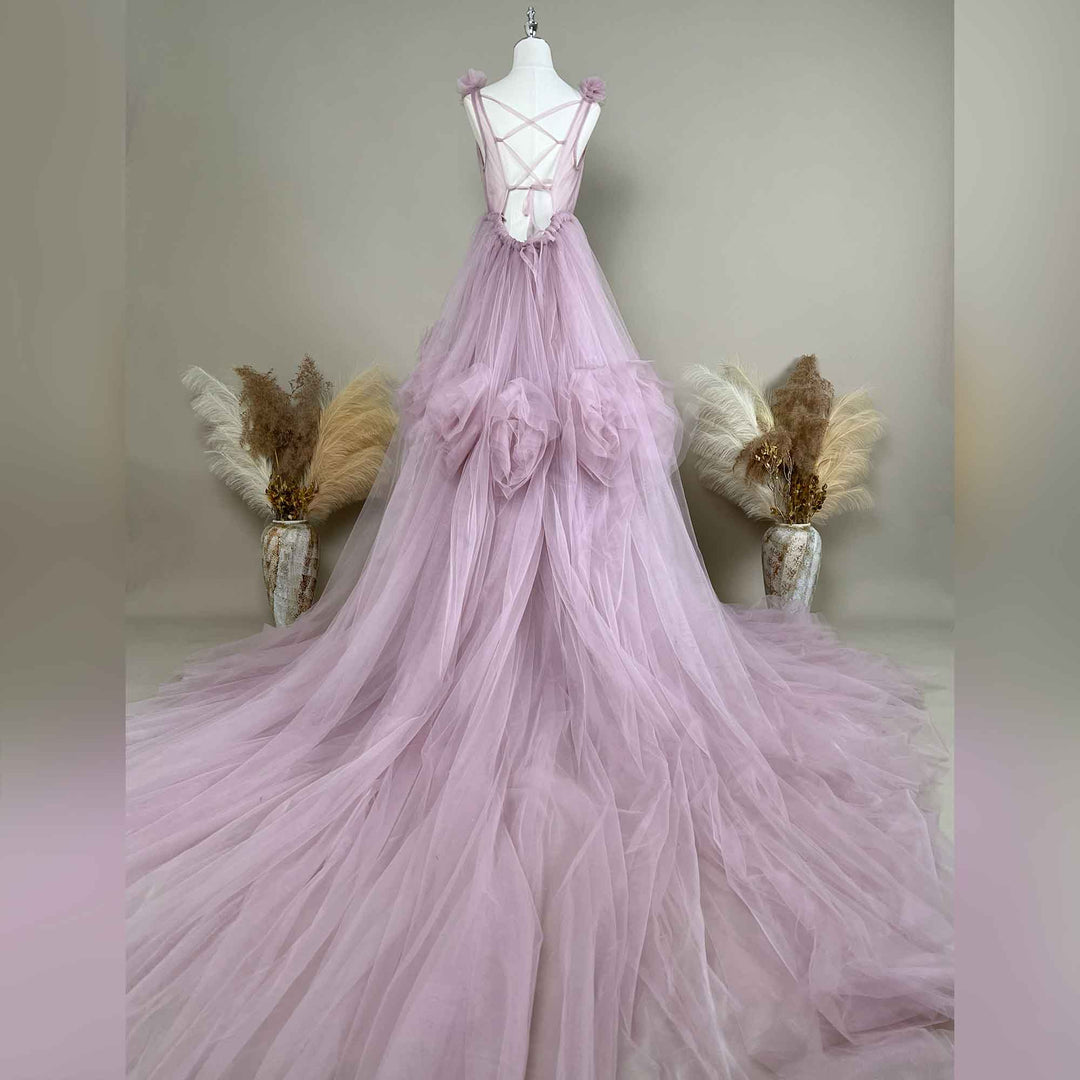 This light purple gown is displayed on a mannequin, showing its crisscross back straps and floral accents.