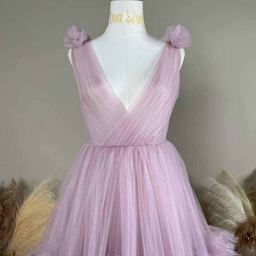 This is a light purple dress on a mannequin, featuring a V-neck and floral shoulder straps. 