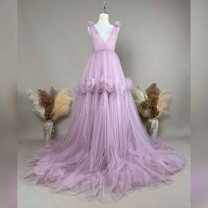 A light purple Mila tulle gown is displayed on a mannequin with floral details on the shoulders, waist, and neckline. 