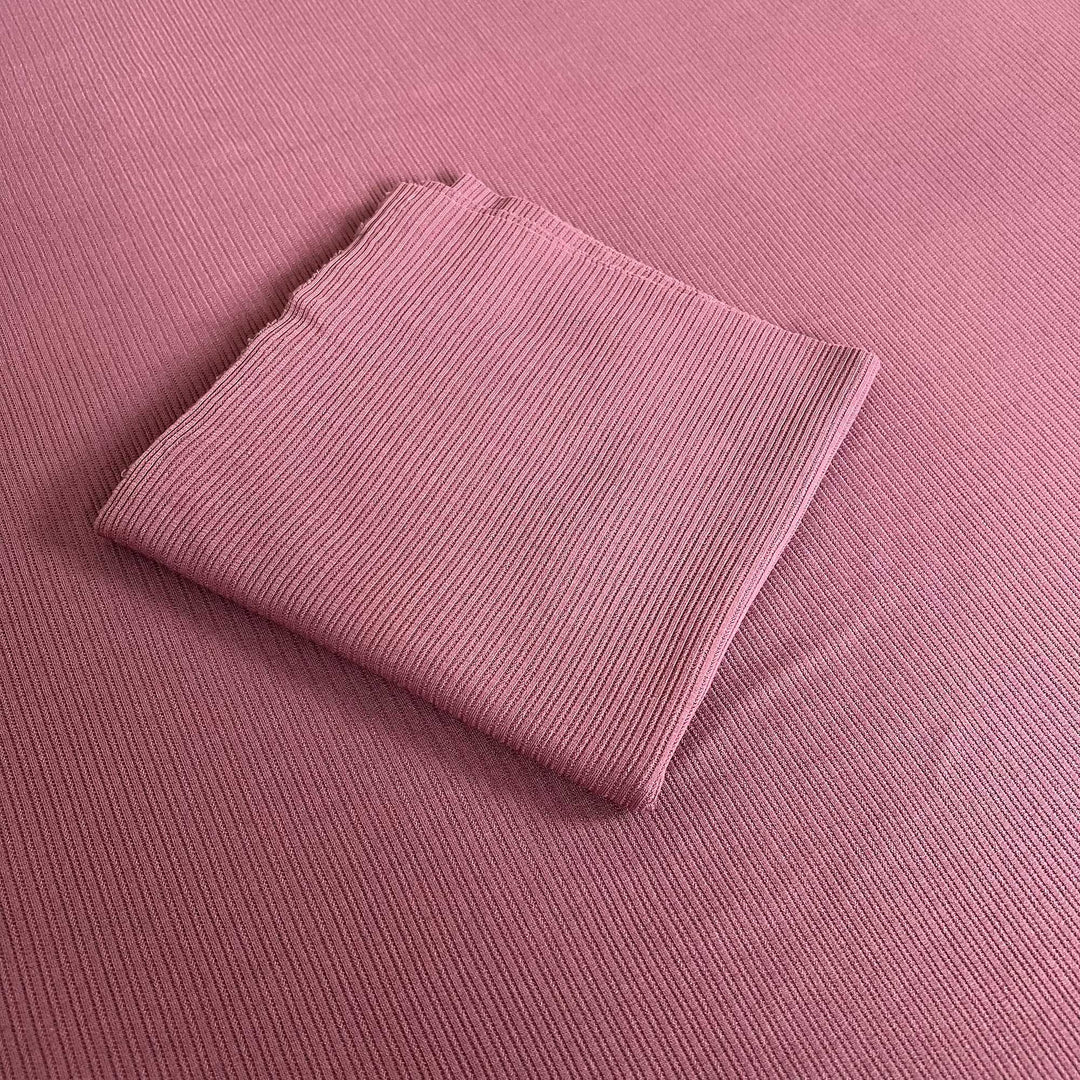 A mauve ribbed knit fabric fills the frame, with a folded piece of the same fabric in the middle.