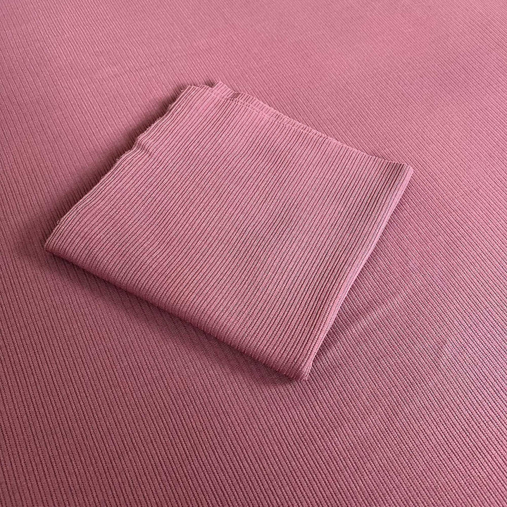 A mauve ribbed knit fabric fills the frame, with a folded piece of the same fabric in the middle.