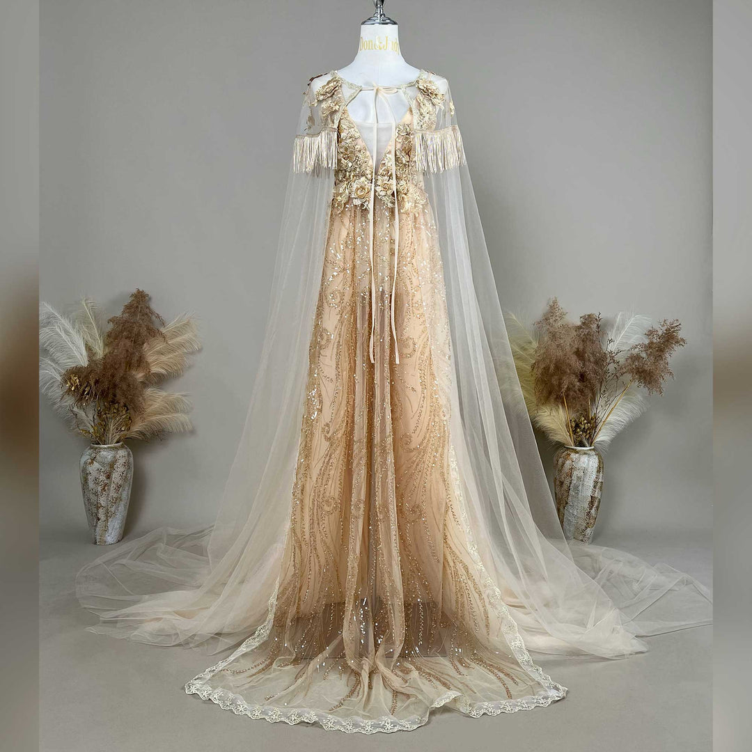 A gold sequined gown with a Pandia tulle cape is displayed on a mannequin, featuring fringe cuffs and a train skirt.