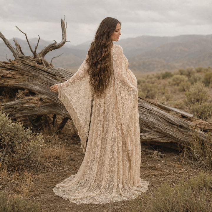 pregnant woman in a khaki lace fringe gown stands with back to camera before deadwood, showing sleeve fringe.