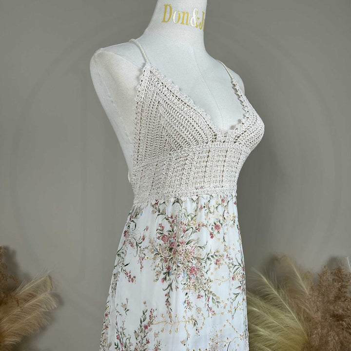 The Urania,an apricot bottom floral maternity maxi dress with spaghetti straps, a crochet bodice details, displayed on a mannequin.