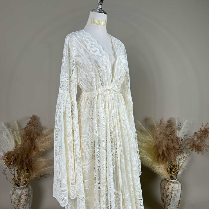 A beige lace ,Zephyra dress with long bell sleeves and a V-neckline, displayed on a mannequin. 